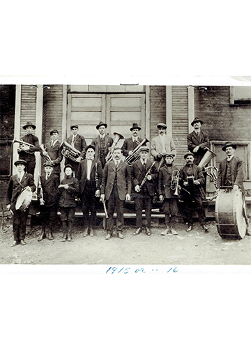 A vintage photograph taken in 1915 or 1916 of Pietro Maccagno holding his clarinet and standing in front of the Ernest, Pennsylvania, band.